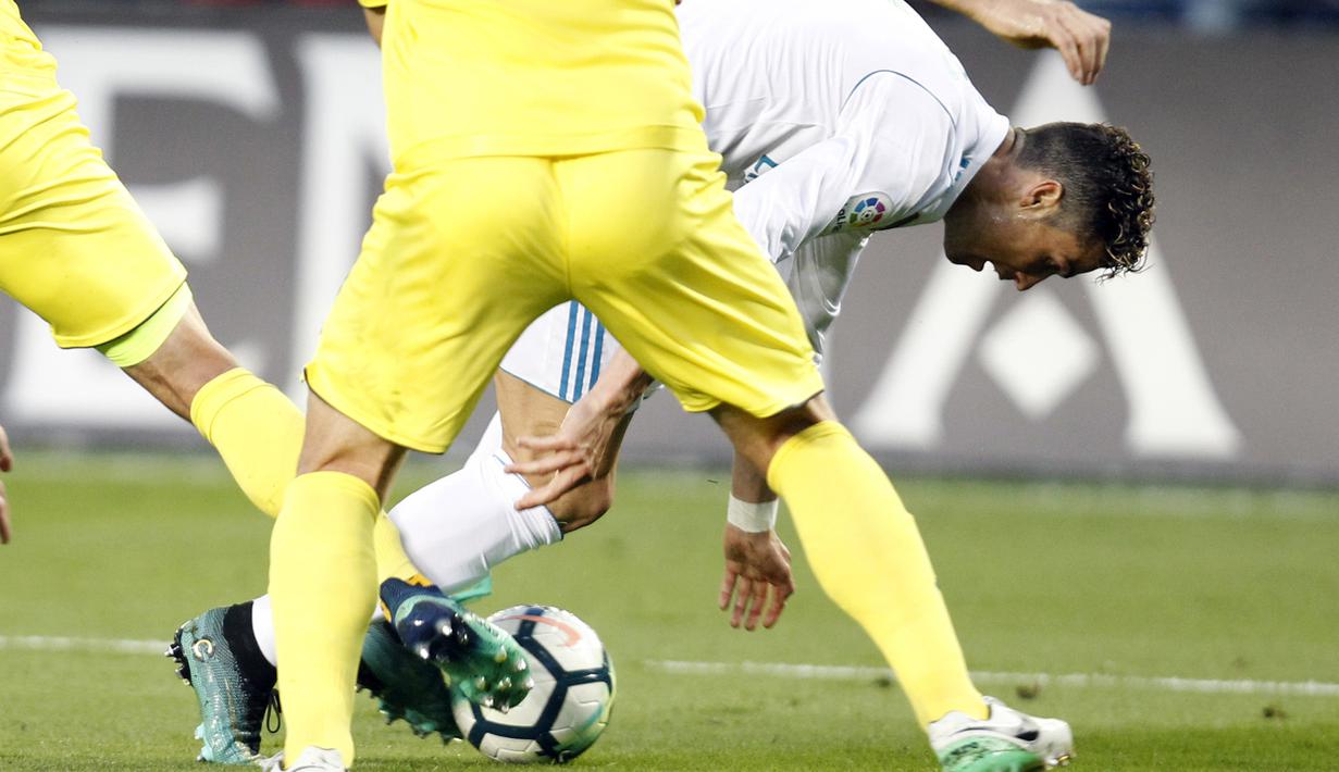 Cristiano Ronaldo berusaha melewati adangan dua pemain Villareal pada laga terakhir La Liga di Ceramica stadium, Villarreal, (19/5/2018). Real Madrid ber,min imbang 2-2. (AP/Alberto Saiz)