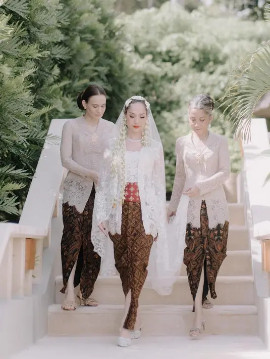 Aishah Sinclair dipercaya menjadi pengiring Bunga Citra Lestari hingga sampai ke tempat akad. Ia pun tampil mengenakan kebaya bridesmaid warna coklat dipadukan bros keemasan dan kain batik coklatnya. [@aishahjennife]