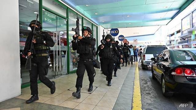 Anggota tim SWAT polisi mengambil posisi di luar salah satu pintu masuk ke mal setelah situasi penyanderaan dilaporkan terjadi di pinggiran kota Manila, 2 Maret 2020.