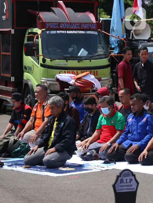 Sejumlah buruh menunaikan salat zuhur di sela aksi Hari Buruh Internasional atau May Day di Jakarta, Sabtu (1/5/2021). Sejumlah massa yang tergabung dalam serikat pekerja menggelar unjuk rasa di Hari Buruh ini. (Liputan6.com/Angga Yuniar)