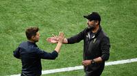 Pelatih Tottenham Hotspur, Mauricio Pochettino berjabat tangan dengan pelatih Liverpool, Jurgen Klopp usai pertandingan final Liga Champions di Stadion Metropolitan Wanda di Madrid pada 1 Juni 2019. Pochettino sebelumnya sempat diincar Barcelona, Manchester United dan Juventus. (AFP/Oscar Del Pozo)