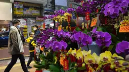 Pot anggrek untuk Tahun Baru Imlek dipajang untuk dijual di apotek untuk merayakan Tahun Baru Imlek di Hong Kong (14/1/2022). Penangguhan sementara penumpang transit berlaku pada 16 Januari 2022 - 15 Februari 2022. (AP Photo/Kin Cheung)