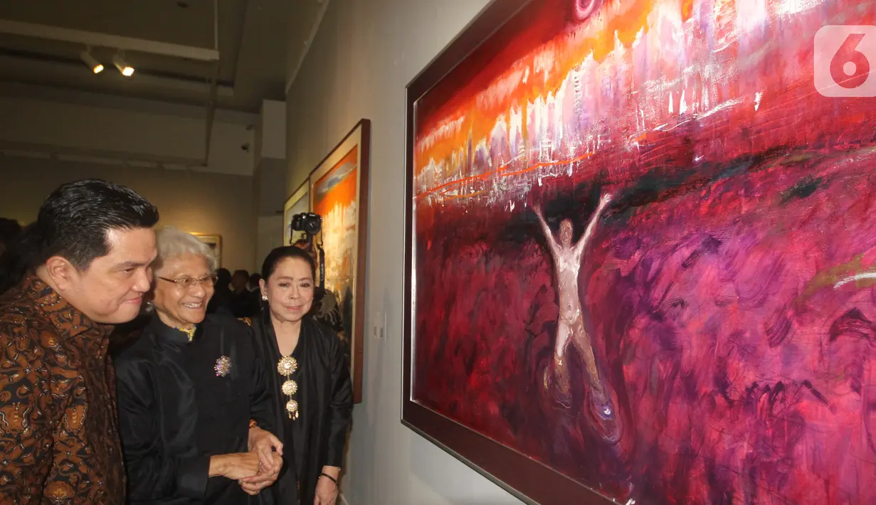 Menteri BUMN Erick Thohir (kiri) didampingi Maestro dan Pelukis Man x Universe Srihadi Soedarsono (tengah) dan Istrinya saat melihat lukisan pada pameran tunggal Srihadi Soedarsono - Man x Universe di Galeri Nasional, Jakarta, Rabu (11/3/2020). (Liputan6.com/HO/Andry)