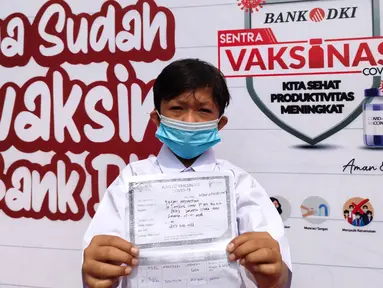 Siswa menunjukan kartu vaksinasi Covid-19 setelah mengikuti program Literasi Keuangan dan Sentra Vaksinasi di SMA 111 Jakarta, Selasa (31/8/2021). Kegiatan digelar Bank DKI berkolaborasi dengan OJK untuk pelajar DKI Jakarta melalui program Satu Rekening dan Pelajar (KEJAR). (Liputan6.com/HO/BDKI)