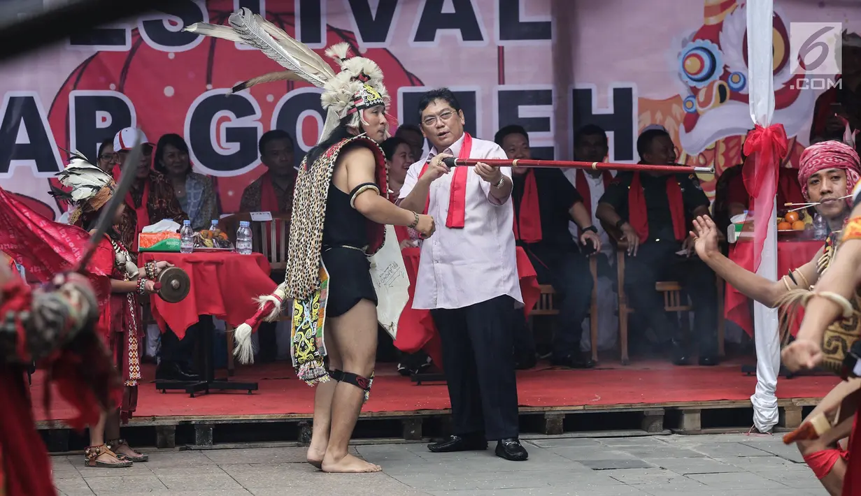 Politikus PDIP Utut Adianto memanah dengan mulut pada acara Festival Cap Go Meh 2570 di Seasons City, Jakarta,  Minggu (24/3). Sekitar 100 tatung pria dan wanita hadir menampilkan atraksi ekstrem menggunakan benda tajam. (Liputan6.com/Fery Pradolo)