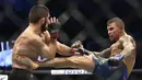 Khabib Nurmagomedov berusaha menghadang tendangan Dustin Poirier dalam pertarungan UFC 242 di Mal Yas di Abu Dhabi, Uni Emirat Arab (7/9/2019). emenangan dari Dustin membuat rekornya masih sempurna. Dari 28 kali turun laga di UFC, Khabib belum tersentuh kekalahan. (AP Photo/ Mahmoud Khaled)
