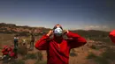 Seorang pria mengenakan kacamata pelindung untuk menyaksikan efek "cincin berlian" saat terjadi gerhana matahari total di Piedra del Aguila, Argentina, Senin (14/12/2020). Gerhana matahari total terlihat dari wilayah Patagonia utara Argentina dan dari Araucania di Chili. (AP Photo/Natacha Pisarenko)