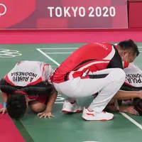 Ganda putri Indonesia Greysia Polii dan Apriyani Rahayu berselebrasi dengan pelatih mereka Eng Hian setelah mengalahkan pasangan China Cheng Qingchen dan Jia Yi pada final badminton ganda putri Olimpiade Tokyo 2020 di Musashino Forest Sport, Senin (2/8/2021). (AP/Dita Alangkara)