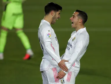 Gelandang Real Madrid, Marco Asensio (kiri) berselebrasi dengan rekannya Lucas Vazquez usai mencetak gol ke gawang Celta Vigo pada pertandingan lanjutan La Liga Spanyol di stadion Alfredo Di Stefano, Minggu (3/1/2021). Madrid menang atas Celta Vigo 2-0. (AP Photo/Manu Fernandez)