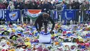 Pemain Leicester City, Darnell Johnson memberi penghormatan kepada korban kecelakaan helikopter yang menewaskan pemilik Leicester City Vichai Srivaddhanaprabha di luar Stadion King Power, Inggris, Senin (29/10). (Paul Ellis/AFP)
