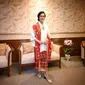 Sri Mulyani tampak menawan dalam balutan kebaya kurung warna putih yang dipadukan kain batik merah motif floral. Tak ketinggalan selendang bermotif dan warna senada yang menambah impresi anggun pada penampilannya.