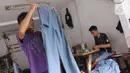 Para pekerja menyelesaikan pembuatan seragam sekolah di usaha konveksi skala rumah tangga Kebayoran Lama, Jakarta, Kamis (9/7/2020). Pandemi virus corona COVID-19 berdampak pada sepinya pesanan pembuatan seragam sekolah. (Liputan6.com/Angga Yuniar)