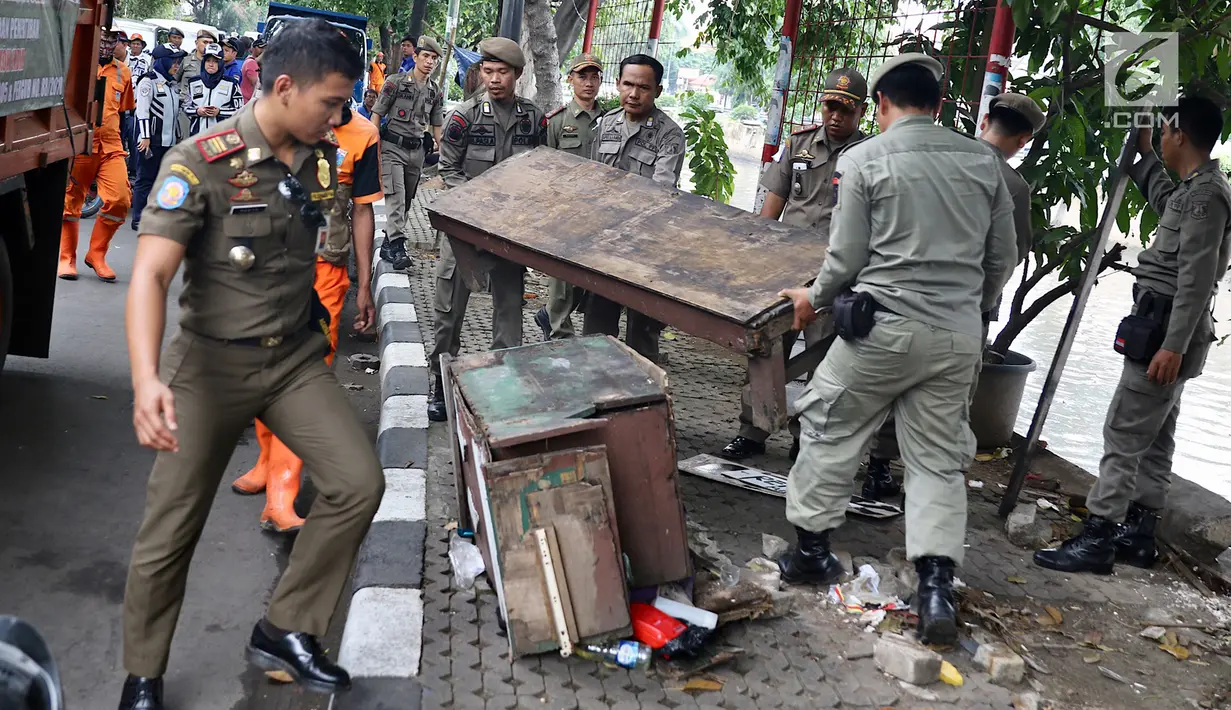 Petugas Satpol PP membongkar lapak saat melakukan penertiban di kawasan pusat perbelanjaan Pasar Baru, Jakarta, Rabu (21/2). Penertiban dilakukan guna mengurangi kesemrawutan serta kesan kumuh di kawasan tersebut. (Liputan6.com/Immanuel Antonius)