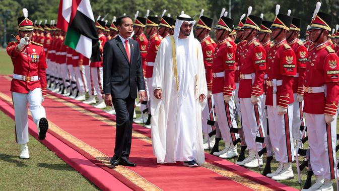 Presiden Joko Widodo (Jokowi)  bersama Putra Mahkota Abu Dhabi, Sheikh Mohamed Bin Zayed Al Nahyan memeriksa pasukan saat kunjungan kenegaraan di Istana Bogor, Kamis (24/7/2019). Keduanya menggelar pertemuan bilateral guna membahas sejumlah kerja sama. (Willy Kurniawan/Pool Photo via AP)