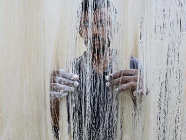 Seorang pekerja menjemur Seviiyan (sejenis bihun) saat proses pembuatan Sheerkhorma di Hyderabad, India. 23 Juni 2015. Sheerkhorma merupakan hidangan manis tradisional khas Ramadan bagi muslim India. (AFP PHOTO/NOAH Seelam)