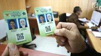Petugas Kementerian Agama (Kemenag) menunjukan kartu nikah di kantor Kemenag, Jakarta, Rabu (14/11). Pada kartu nikah terdapat barcode yang berisi data-data pasangan pengantin. (Liputan6.com/Angga Yuniar