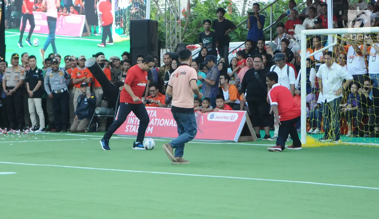 Gubernur DKI Jakarta Anies Baswedan bermain bola saat menghadiri Kick Off Pembangunan Jakarta International Stadium di Jakarta, Kamis (14/3). Stadion ini akan dibangun dengan konsep internasional. (Liputan6.com/Herman Zakharia)