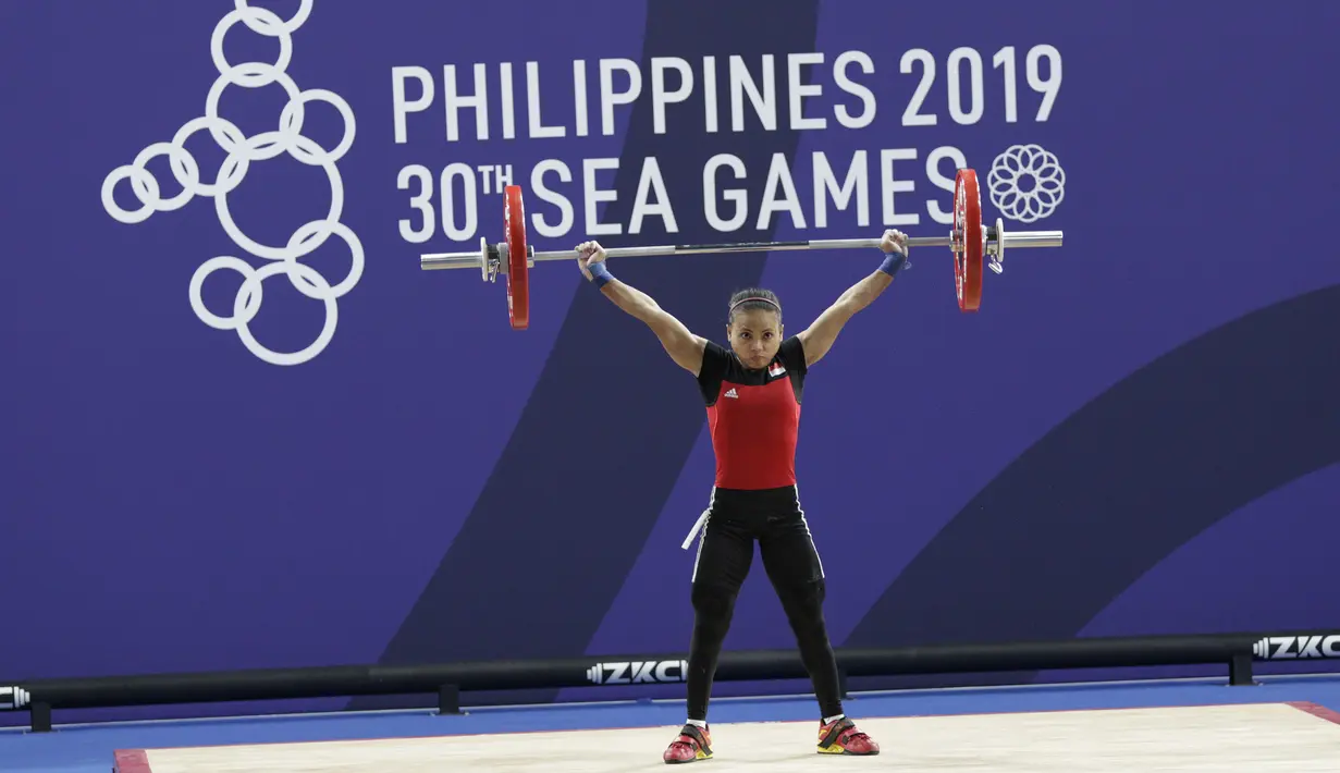 Lifter Lisa Setiawati melakukan angkatan pada SEA Games 2019 cabang angkat besi nomor 45 kg di Stadion Rizal Memorial, Manila, Minggu (1/12). Dirinya meraih perak dengan total angkatan 169 kg. (Bola.com/M Iqbal Ichsan)