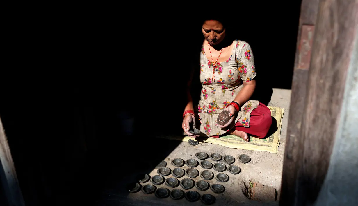 Seorang pembuat tembikar membuat lampu tanah untuk Festival Tihar atau Yama Panchak di Bhaktapur, Nepal, 21 Oktober 2022. Selama festival lima hari yang mirip dengan Festival Diwali di India tersebut, umat Hindu mendekorasi rumah dan tempat ibadah mereka. (AP Photo/Niranjan Shrestha)