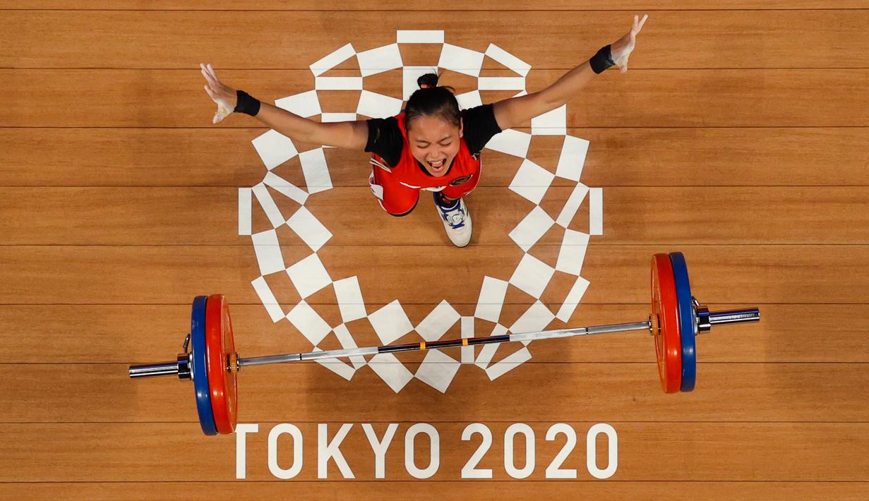 Foto yang diambil dengan kamera robot ini menunjukkan reaksi Windy Cantika Aisah dari Indonesia saat berlaga dalam kompetisi angkat besi 49kg putri pada Olimpiade Tokyo 2020 di Tokyo International Forum, Tokyo pada 24 Juli 2021. (AFP/Pool/Chris Graythen)