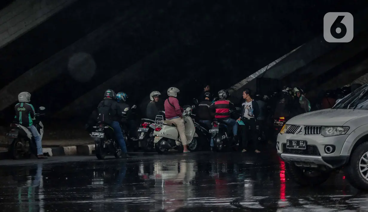 Pengendara sepeda motor memenuhi ruas jalan ketika berteduh di kolong Fly Over Cawang, Jakarta, Selasa (17/12/2019). Perilaku tersebut selain menimbulkan ketidaknyamanan pengguna jalan lainnya, juga memicu kemacetan. (Liputan6.com/Faizal Fanani)
