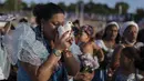 Seorang wanita mencium seekor merpati dalam ritual untuk dewi laut Afrika Yemanja di Pantai Ramirez di Montevideo, Uruguay, Rabu (2/2/2022). Para pemuja mendatangi pantai pada pada hari raya Yemanja, membawa lilin, bunga, madu dan buah untuk menghormati dewi laut. (AP Photo/Matilde Campodonico)
