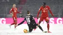 Pemain Bayern Munchen Alphonso Davies (kanan) memperebutkan bola dengan pemain Arminia Bielefeld Fabian Kunze pada pertandingan Bundesliga di Allianz Arena, Munich, Jerman, Senin (15/2/2021). Laga berakhir dengan skor 3-3. (AP Photo/Andreas Schaad, Pool)