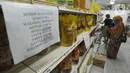 Pembeli berbelanja dekat kertas pemberitahuan pembatasan pembelian di supermarket Kawasan Cirendeu, Tangsel, Rabu (18/3/2020). Satgas Pangan meminta pedagang membatasi penjualan bahan pokok yakni beras, gula, minyak goreng dan mi instan untuk menjaga stabilitas harga. (merdeka.com/Arie Basuki)