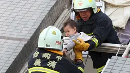 Petugas penyelamat mengevakuasi seorang bayi yang selamat akibat gempa di Tainan, Taiwan Selatan (6/2). Gempa terjadi pukul 4 subuh tadi telah menghancurkan beberapa apartemen di kawasan Wei Guan, Tainan, Taiwan. (REUTERS/Stringer)