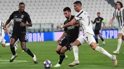 Penyerang Juventus, Cristiano Ronaldo, berebut bola dengan bek Olympique Lyon, Leo Dubois, pada laga leg kedua Liga Champions 2019/2020 di Stadion Allianz, Sabtu (8/8/2020) dini hari WIB. Juventus kalah agregat 2-2 atas Olympique Lyon. (AFP/Miguel Medina)