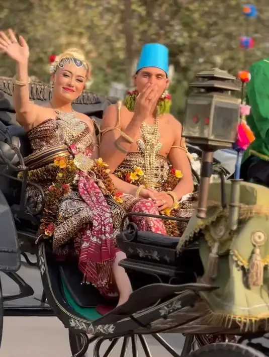 Amanda dan Christian tampak juga menjalani prosesi kirab di hari pernikahannya. Senyum manis dan melambaikan tangan Amanda di atas kereta kencana. Amanda dan Christian sama-sama mengenakan busana dodotan Yogyakarta yang menonjolkan kegagahan dan keanggunan masing-masing. [Foto: Instagram/dwinathan9]