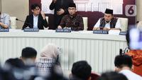 Ketua Komisi Pemilihan Umum (KPU) Republik Indonesia, Hasyim Asyari (tengah) didampingi anggota KPU August Mellaz (kiri) dan Mochammad Afifuddin (kanan) memberikan keterangan di kantor KPU, Jakarta, Senin (12/2/2024). (Liputan6.com/Angga Yuniar)