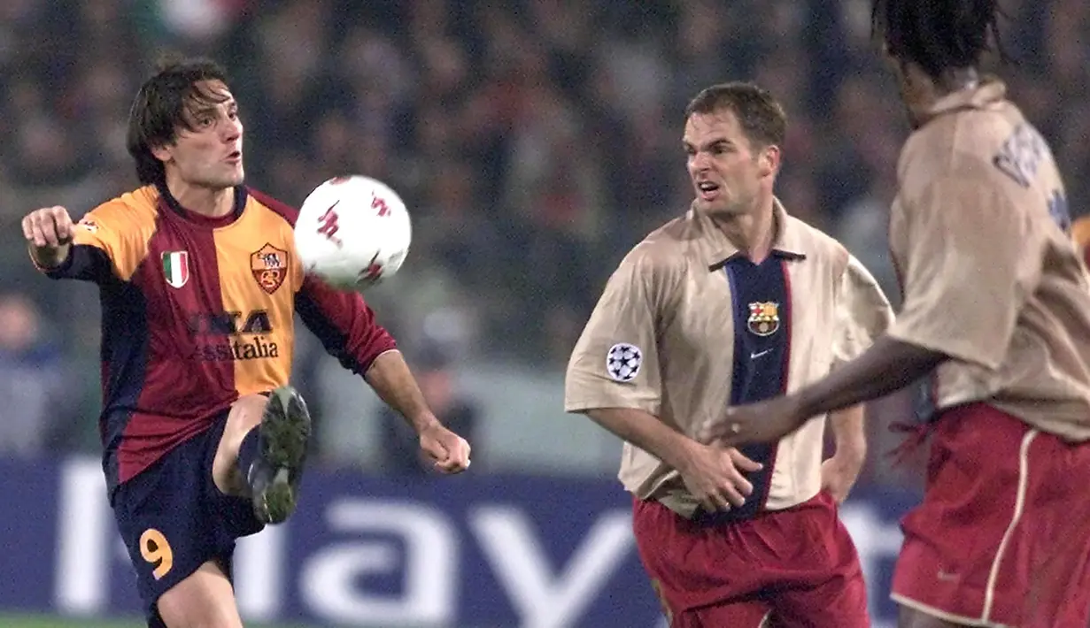 Bek Barcelona, Frank de Boer (tengah) berusaha merebut bola dari penguasaan striker AS Roma, Vincenzo Montella pada laga Liga Champions 2001/2002 di Olympic Stadium, Roma (26/2/2002). Hingga pensiun pada Juli 2005, Frank de Boer total bermain dalam 81 laga di Liga Champions bersama Ajax, Barcelona dan Galatasaray dengan torehan 7 gol dan 5 assist. Satu trofi berhasil diraihnya bersama Ajax Amsterdam pada musim 1994/1995. (AFP/Gabriel Bouys)