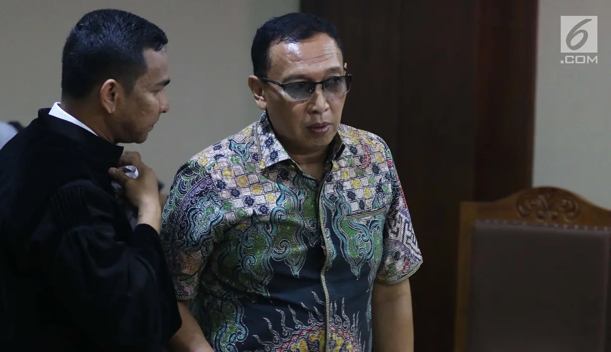Sekertaris Jenderal Komite Olahraga Nasional Indonesia (KONI) Ending Fuad Hamidy berbincang dengan kuasa hukumnya saat menjalani sidang perdana sebagai terdakwa di Pengadilan Tipikor, Jakarta, Senin (11/3). (Liputan6.com/Johan Tallo)
