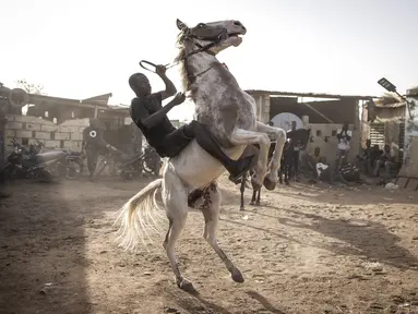 Seorang joki berlatih untuk mengendalikan kudanya di Ouagadougou (1/2/2022). Bagi banyak orang budaya kuda Burkinabe memainkan peran penting dalam kehidupan mereka, mulai dari beternak kuda untuk balap atau berpakaian, atau hingga acara pacuan kuda hari Minggu di trek lokal. (AFP/John Wessels)