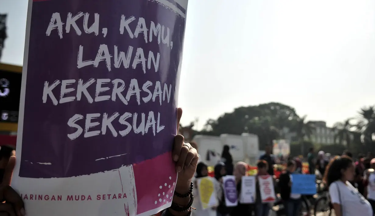 Massa yang tergabung dalam Jaringan Muda Setara menunjukkan poster saat aksi menuntut keadilan untuk WA korban pemerkosaan di kawasan Bundaran HI, Jakarta, Minggu (5/8). (Merdeka.com/Iqbal S. Nugroho)