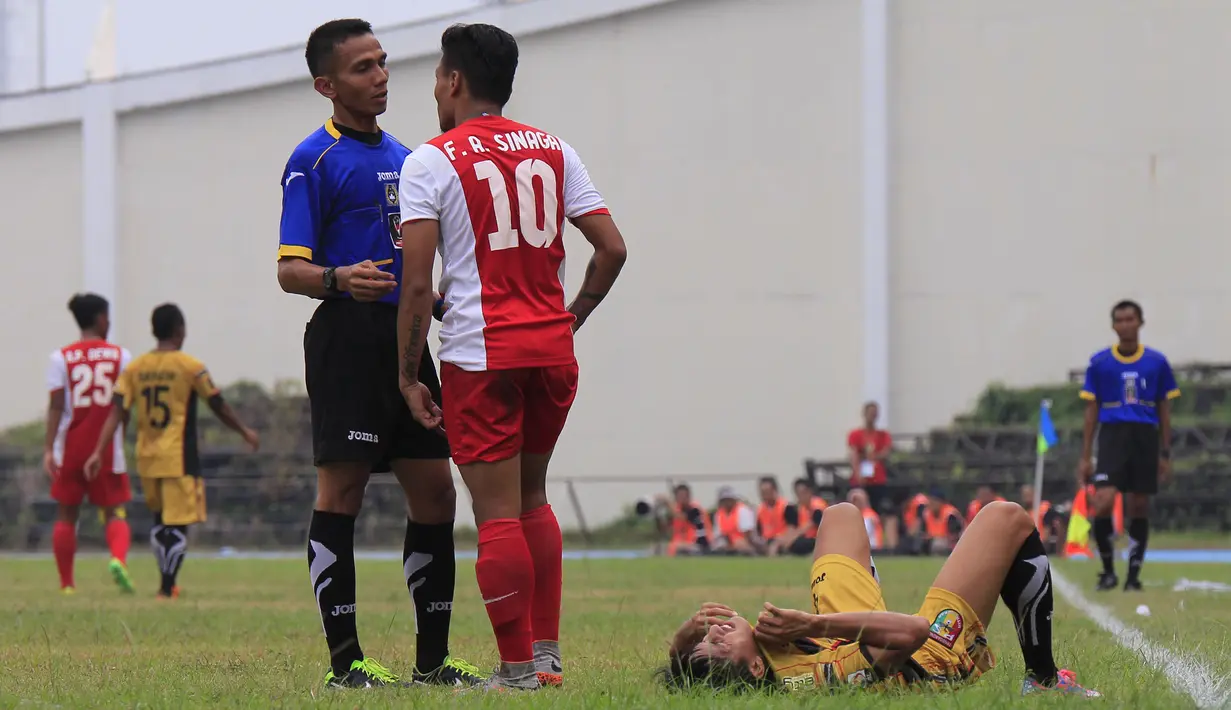 Wasit memberi peringatan kepada Ferdinand Sinaga setelah melanggar pemain Mitra Kukar, Mahdi Fakhri Akbar, dalam partai Piala Presiden 2015 antara Mitra Kukar melawan PSM di Stadion Aji Imbut, Tenggarong, Sabtu (19/9/2015). (Bola.com/M. Ridwan)