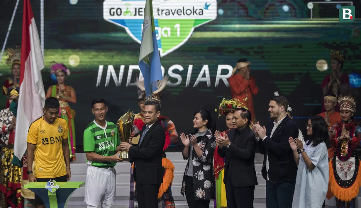 Pemain Bhayangkara FC, Indra Kahfi menyerahkan piala bergilir saat peluncuran Liga 1 Indonesia 2018 di Studio 5 Indosiar, Jakarta, Senin (19/3/2018). Liga 1 akan mulai digelar pada Jumat (23/3). (Bola.com/Vitalis Yogi Trisna)