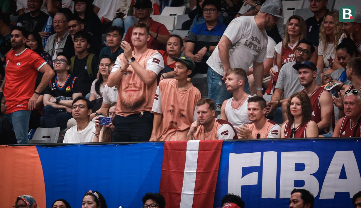 Sejumlah pendukung Latvia mengenakan kaos bergambar Davis Bertans saat menonton laga perdana Grup H Piala Dunia FIBA 2023 antara Timnas Basket Latvia melawan Timnas Basket Lebanon di Indonesia Arena, Senayan, Jakarta, Jumat (25/08/2023). Lebanon menang dengan skor 109-70. (Bola.com/Bagaskara Lazuardi)
