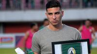 Brian Ferreira saat mendapat kenang-kenangan dari tim PSS sesudah pertandingan melawan Bali United di Stadion Maguwoharjo, Sleman (6/11/2019). (Bola.com/Vincentius Atmaja)