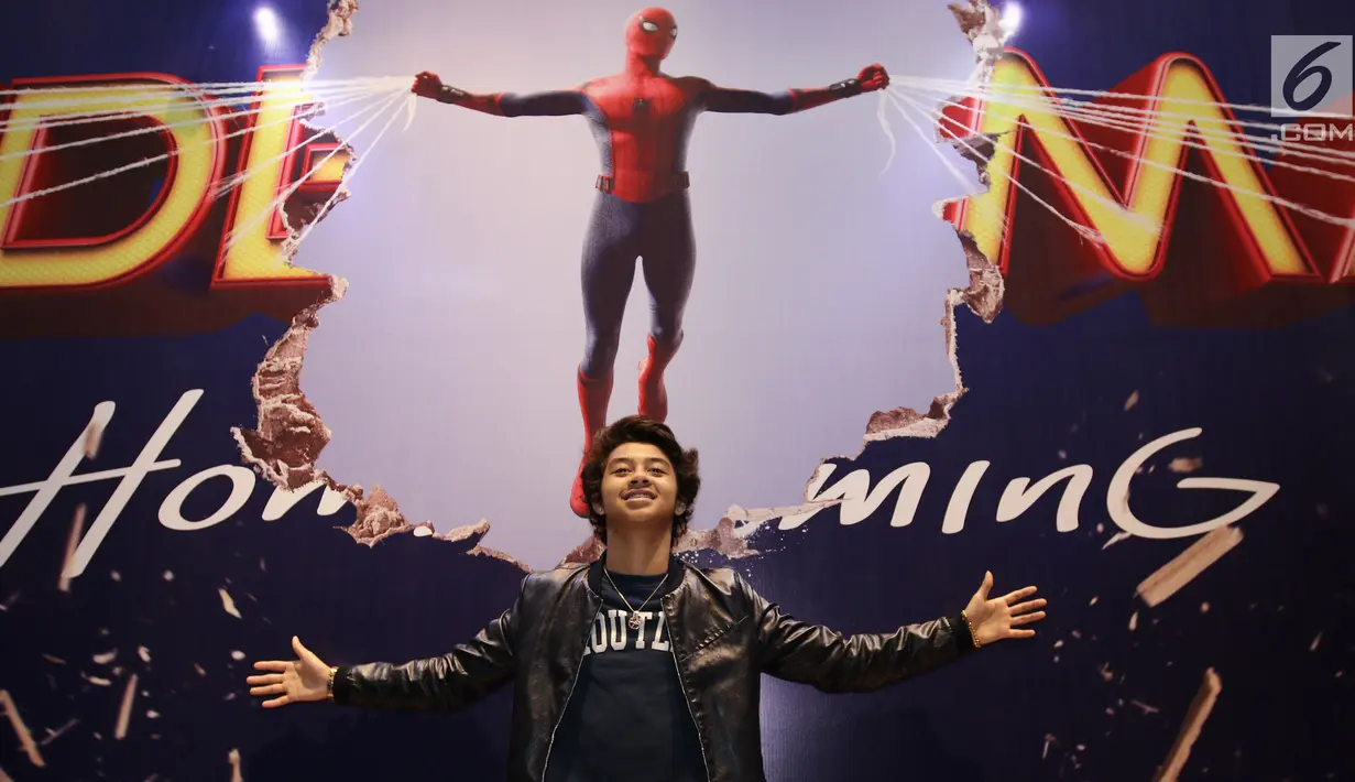 Aktor Bastian Steel bergaya di depan poster film Spiderman: Homecoming saat nobar (nonton bareng) di Gandaria City, Selasa (4/7). (Liputan6.com/Herman Zakharia)