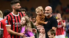 Penyerang AC Milan #09 Olivier Giroud dan putrinya Jade merayakan di samping pelatih AC Milan Stefano Pioli dan kerabatnya pada akhir pertandingan terakhir mereka saat melawan Salernitana dalam matchday terakhir Serie A di San Siro, Minggu (26/5/2024) dini hari WIB. (MARCO BERTORELLO / AFP)