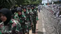 Korps Wanita Angkatan Darat (Kowad) bersiap berbaris di balik kawat berduri di depan Polda Metro Jaya, Senin (23/1). Polwan dan Kowad berhijab dikerahkan untuk mengamankan aksi massa FPI yang mengawal pemeriksaan Rizieq Shihab (Liputan6.com/Faizal Fanani)