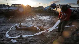 Jess Elderedge membuat 'lumpur angel' dimana rekannya berada di tengah lingkaran kertas toilet saat berlangsungnya hari terakhir Festival Deni Ute Muster di Deniliquin, New South Wales, Australia, (1/10). (REUTERS/Jason Reed)