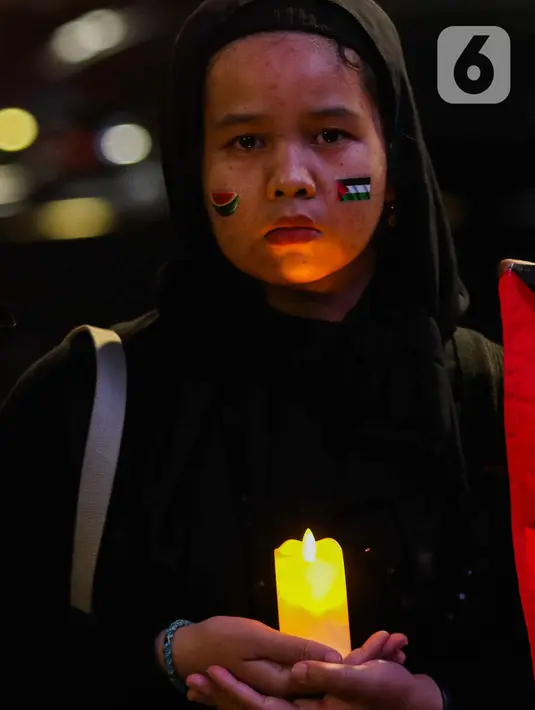 Selain itu, mereka juga menyalakan lilin dan menampilkan video mapping berisi tuntutan terkait serangan Israel di Jalur Gaza. (Liputan6.com/Herman Zakharia)