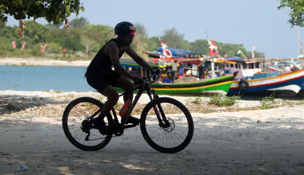 Peserta memacu sepeda ketika mengikuti Rhino Cross Triathlon 2018 di Kawasan KEK Tanjung Lesung, Pandeglang, Banten, Minggu (30/9). Rhino Cross Triathlon diikuti lebih dari 200 peserta dari dalam negeri dan manca negara. (Liputan6.com/HO/Nick Hanoatubun)