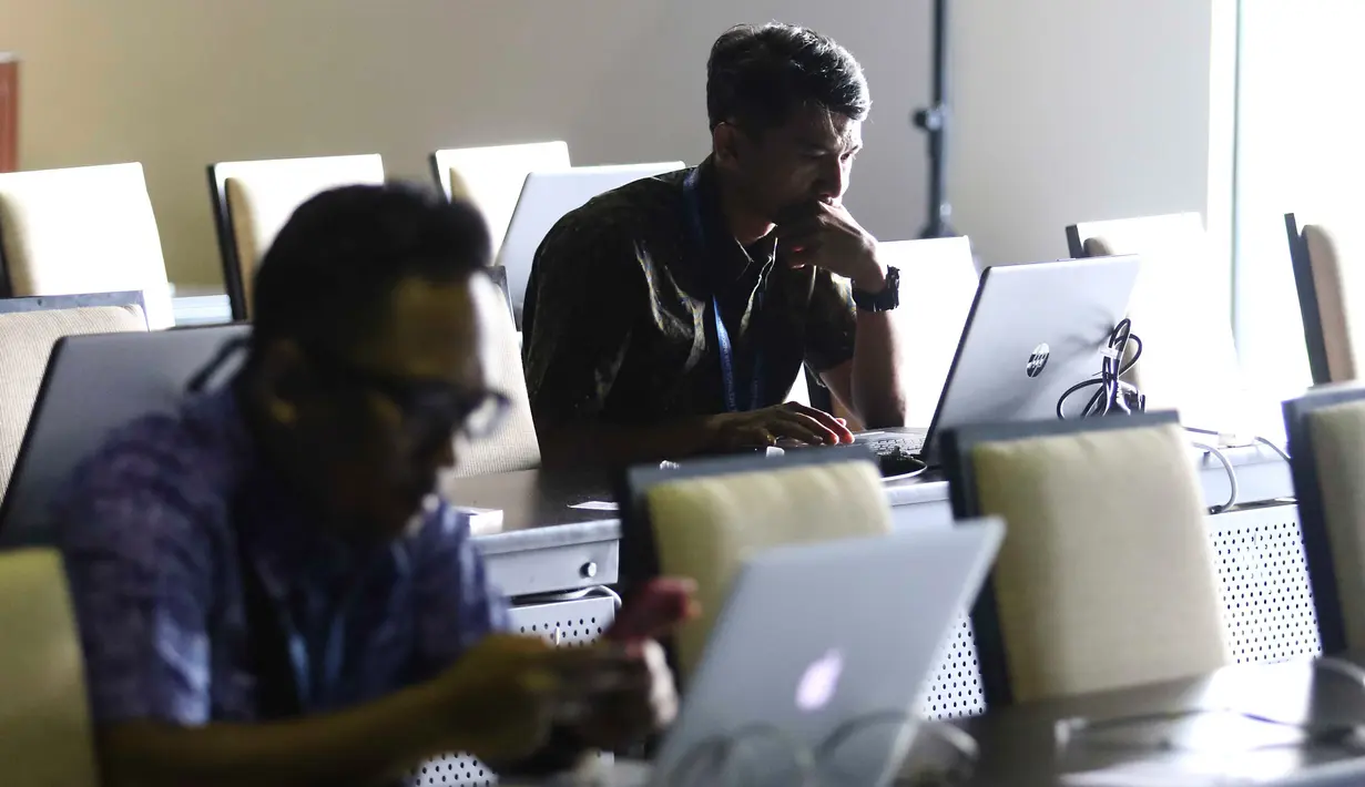Jurnalis berbagai negara mengetik berita pertemuan tahunan IMF-Bank Dunia di Nusa Dua, Bali, Senin (8/10). Menkominfo Rudiantara memastikan fasilitas internet kencang untuk tamu dan media dalam pertemuan tahunan ini. Liputan6.com/Angga Yuniar)