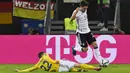 Pemain Rumania Valentin Mihaila (kiri) berebut bola dengan pemain Jerman Jonas Hofmann pada pertandingan Grup J kualifikasi Piala Dunia Qatar 2022 di Hamburg, Jerman, 8 Oktober 2021. Jerman menang 2-1. (John MACDOUGALL/AFP)