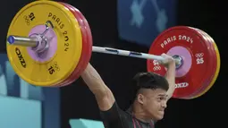 Atlet angkat besi Indonesia, Rizki Juniansyah berhasil mengangkat beban seberat 155 kg pada angkatan snatch saat berlomba pada kelas 73 kg putra cabor angkat besi Olimpiade Paris 2024 di Paris Expo Porte de Versailles, Paris, Kamis (8/8/2024). (AP Photo/Kin Cheung)