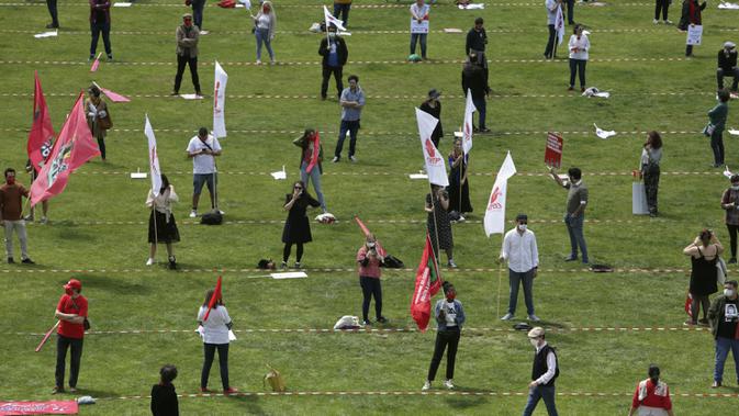 Serikat pekerja menerapkan jaga jarak dan mengenakan masker saat memperingati Hari Buruh di tengah pandemi COVID-19 di Lisbon, Portugal, Jumat (1/5/2020). Delegasi serikat pekerja memperingati Hari Buruh dengan persetujuan Kementerian Kesehatan dan Dalam Negeri Portugal. (AP Photo/Armando Franca)